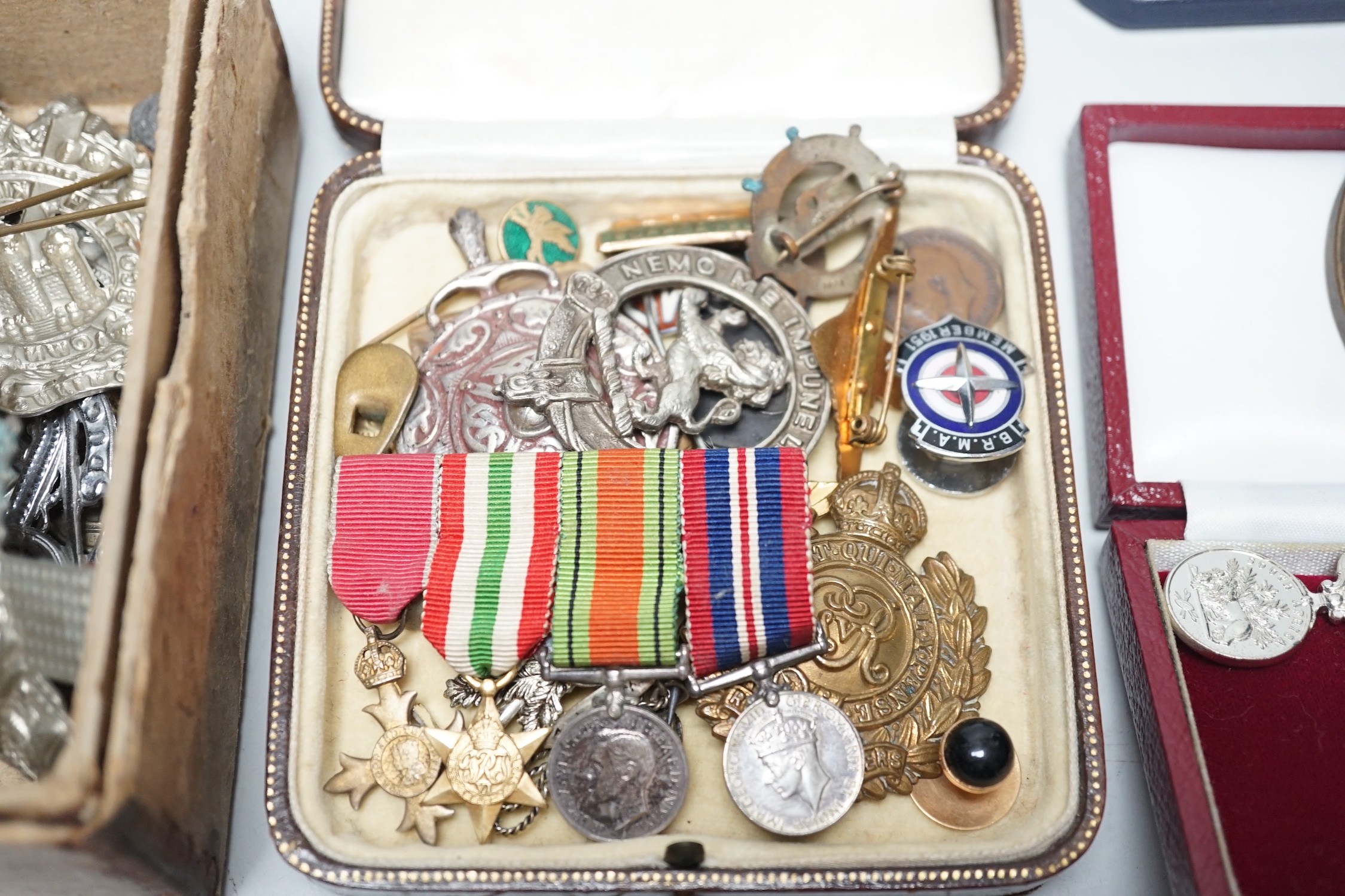 Two powder flasks and militaria including cap badges and miniature medals